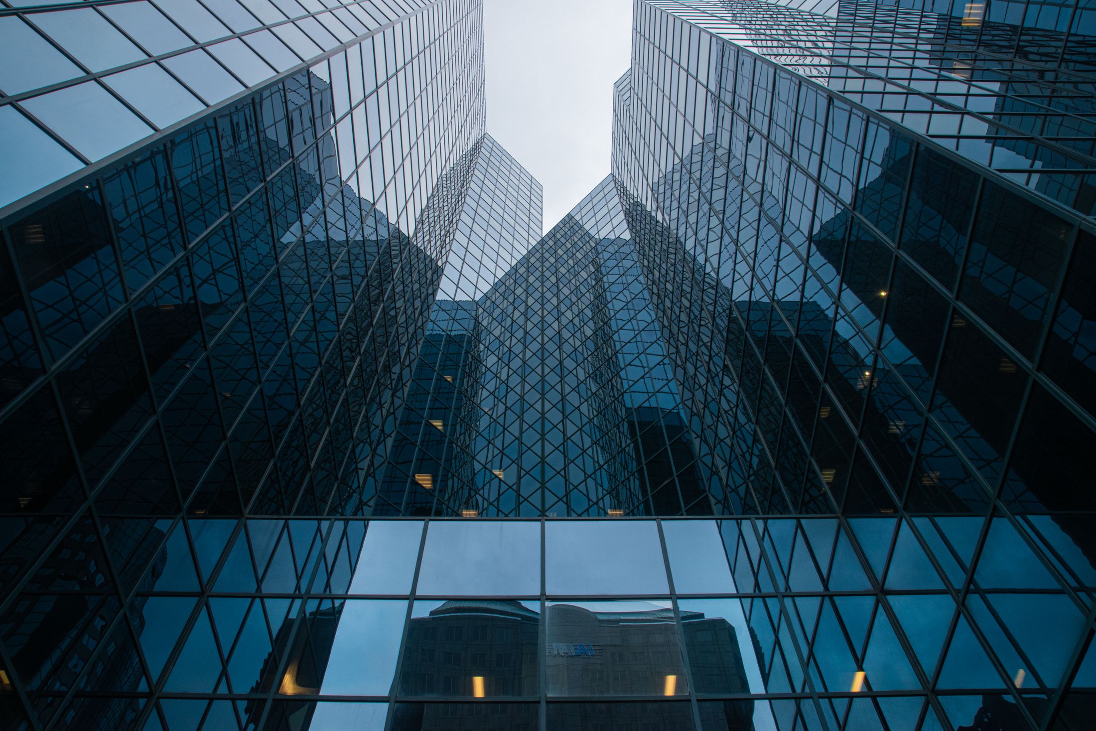 View looking up between office towers with reflective glass facades