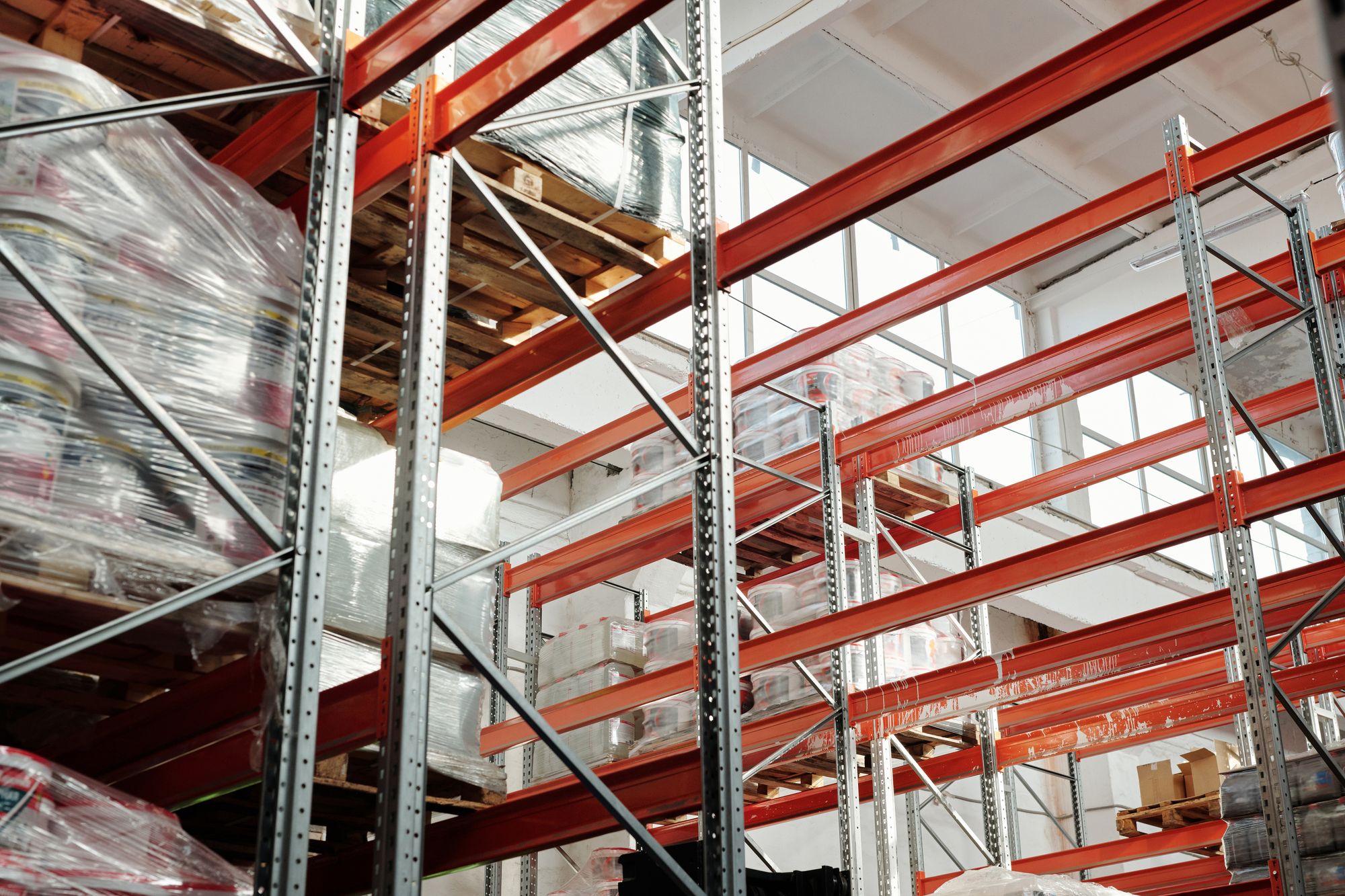 Pallets of wrapped goods on tall warehouse storage racks